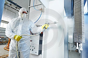 Industrial metal coating. Man in protective suit, wearing a gas