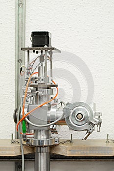 Industrial metal piping with electric cables and a magnet inside a science laboratory