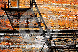 Industrial metal staircase against a brick wall background