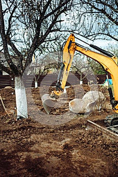 Industrial mini excavator scoop moving earth and doing landscaping works