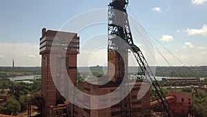 Industrial mining mine red iron ore headframe aerial drone takeoff up camera movement sunset Krivoy Rog Ukraine