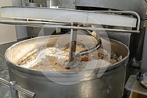 Industrial mixer with flour, salt, sugar, yeast for production of bread in industrial environment. One of stages of