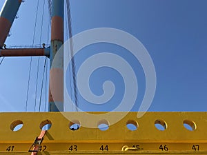 Industrial motiv with giant crane and steel constructions a deep blue sky with copy space for text. Strong blue and yellow colors