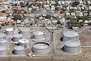 Industrial Oil Tanks Standing Beside Suburban Residential Area