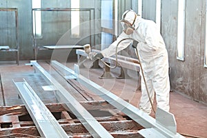 Industrial painter in chamber painting metal detail