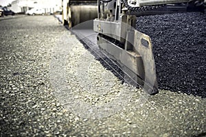 Industrial pavement truck laying fresh asphalt, bitumen during road works. Construction of highways