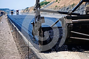 Industrial pavement truck laying fresh asphalt photo