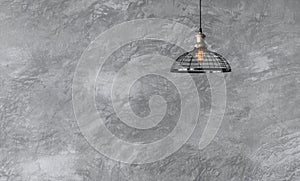 Industrial pendant lamps against rough wall with gray cement plaster.