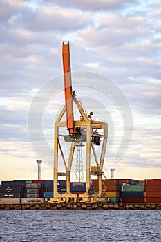 Industrial photo of unloading cranes and equipment near river docks