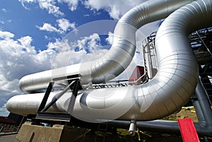 Industrial pipelines and cables against blue sky