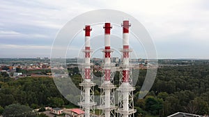 Industrial plant three chimney drone pan shot, aerial shot of factory above the cityscape