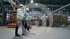 Industrial plant unit with two inspectors walking along it