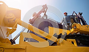 Industrial portrait of working man, excavator driver climbs into cab to perform work on construction site