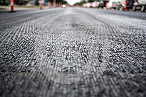 Low angle shot across a scarified street under construction with lanes on either side blocked off. photo