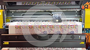 Industrial printing on woven material, modern digital inkjet printer puts a picture on a cloth canvas