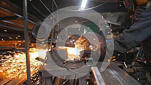 Industrial professional worker use saw cutting machine to cut metal tube. Guy in safety protection wear with circular