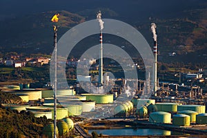 Industrial refinery and storage tanks with smokestack