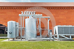 Industrial refrigeration system with compressor and metal tanks outside the wine production plant. Thermovinification