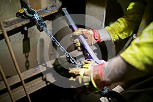 Industrial rigger wearing safety glove inspecting pulleys equipment 1 Tone purple come along