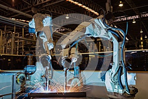 Industrial robot in car factory is welding assembly part