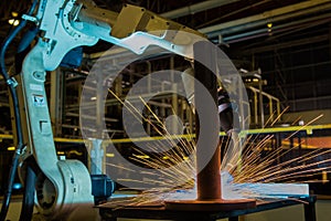 Industrial robot is welding automotive part in factory