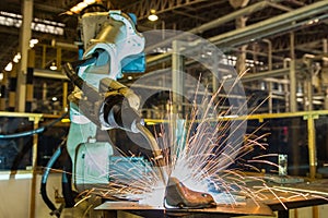 Industrial robot is welding automotive part in factory