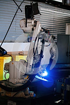 Industrial robot is welding metal machine part