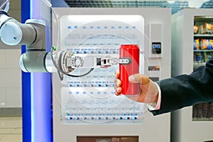 Industrial robotic gripping red soda can for sending to businessman