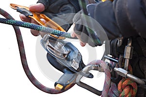 Industrial rope access worker hand connecting Nylon low stretch rope into descender which its attached with harness loop