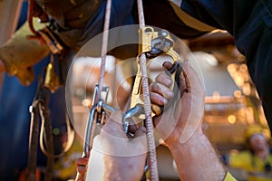 Industrial rope access worker hand using ascender clipping into the Nylon low stretch rope photo