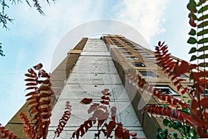 Industrial rope access worker hanging from the building while painting the exterior facade wall. Industrial alpinism concept image