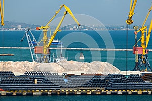 Industrial seaport infrastructure, sea, cranes and minerals, metal and bundles of wire, the concept of marine cargo transportation