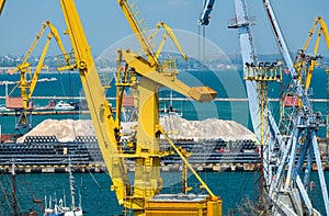 Industrial seaport infrastructure - sea, cranes and minerals, metal and bundles of wire, concept of marine cargo transportation