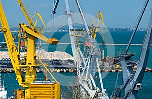 Industrial seaport infrastructure - sea, cranes and minerals, metal and bundles of wire, concept of marine cargo transportation