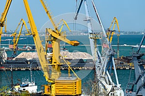 Industrial seaport infrastructure - sea, cranes and minerals, metal and bundles of wire, concept of marine cargo transportation