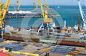 Industrial seaport infrastructure - sea, cranes and minerals, metal and bundles of wire, railcars on railroad, concept of marine