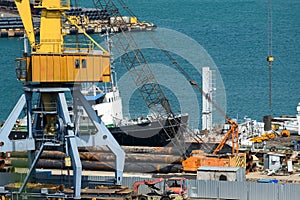 Industrial seaport infrastructure, sea, cranes and raw materials, metal structures and ship, the concept of marine cargo