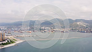 Industrial seaport Novorossiysk , top view. Port cranes and cargo ships and barges. Loading and shipment of cargo at