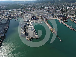 Industrial seaport, top view. Port cranes and cargo ships and barges.