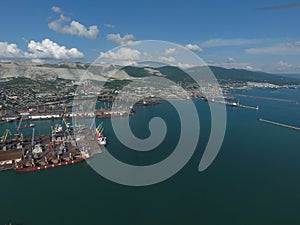 Industrial seaport, top view. Port cranes and cargo ships and barges.