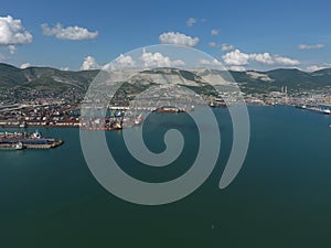 Industrial seaport, top view. Port cranes and cargo ships and barges.