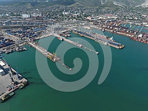 Industrial seaport, top view. Port cranes and cargo ships and barges.