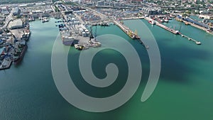 Industrial seaport, top view. Port cranes and cargo ships and barges.