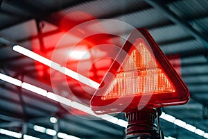 Industrial setting with red warning light emitting bright glow, metal ceiling in background