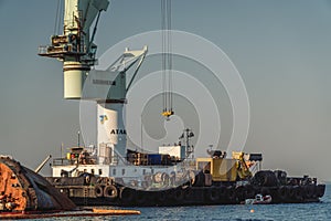 Industrial ship crane lifts old sunken tanker Delfi from Black Sea in Odessa, Ukraine 26 August 2020. Ship crashed near shore sea