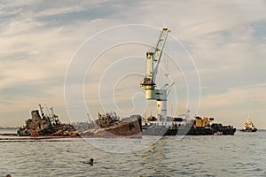 Industrial ship crane lifts old sunken tanker Delfi from Black Sea in Odessa, Ukraine 26 August 2020. Ship crashed near shore sea