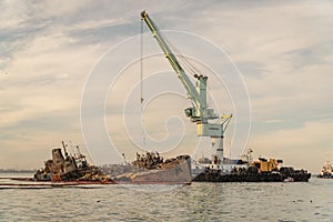 Industrial ship crane lifts old sunken tanker Delfi from Black Sea in Odessa, Ukraine 26 August 2020. Ship crashed near shore sea