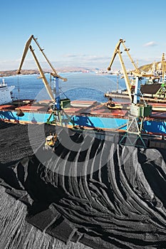 Industrial ship, Portal cranes. Loading coal into the holds of the ship in the seaport