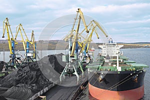 Industrial ship, Portal cranes. Loading coal into the holds of the ship in the seaport