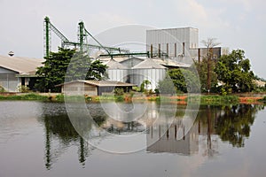 Industrial, silo near pond.